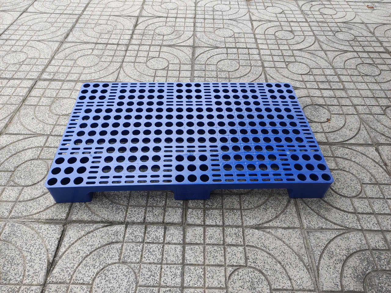 Chủng pallet nhựa nguyên sinh lót sàn giá rẻ chân cao 100 mm tại Nha Trang, mặt nhựa, khối nguyên cứng cáp. Chuyên sử dụng lót hàng hóa tại Nhà Máy và kho bãi chuẩn HACCP tại Pallet Nhựa Gạo Nam tại Nha Trang.